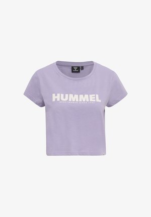 Camiseta corta lila con mangas cortas y texto blanco con el logo HUMMEL en el pecho, escote redondo y etiqueta negra de la marca en el interior del cuello.