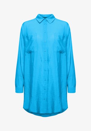 Vaaleansininen, pitkähihainen nappikauluspaita tekstuurimaisella kankaalla. Sisältää kauluksen ja kaksi rintataskua, joissa on kaareva helma.