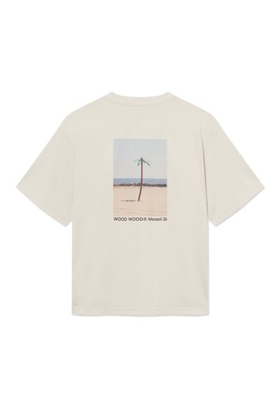 Μπεζ Τ-shirt με εκτύπωση στην πλάτη που απεικονίζει έναν μοναχικό φοίνικα σε μια αμμώδη παραλία κάτω από έναν καθαρό ουρανό, με το κείμενο «WOOD WOOD® Marpoli 26».
