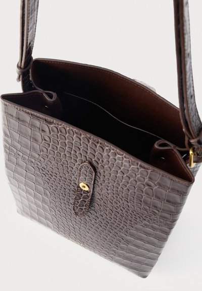 Σκούρο καφέ δερμάτινη τσάντα crossbody με ανάγλυφη υφή κροκό, χρυσό κούμπωμα και ρυθμιζόμενο λουρί, με ανοιχτό εσωτερικό χώρο.