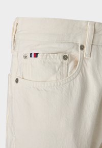 Crèmekleurige jeans met een ritsluiting, vijf zakken en een textiele textuur. Voorzien van een klein rood, wit en blauw logo op de voorzak.