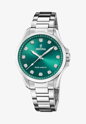 Reloj de acero inoxidable plateado con una esfera color verde azulado, doce marcadores similares a diamantes, función de energía solar y un diseño de pulsera pulido.