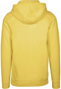 Kollane kapuutsiga pusakas, millel on pikad varrukad ja pehme tekstuur. Omab ribatud äärt ja varrukaid, et tagada mugav istuvus.