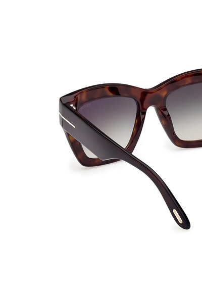 Kilpikonnakuosiset aurinkolasit, joissa on geometrinen kissansilmät-muotoilu. Harmaat liukuvärjätyt linssit ja ohuet metalliset yksityiskohdat temppeleissä. Tyylikkäästi viimeistelty pinta.