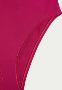 Body fuchsia en tissu lisse et extensible. Dispose d'un décolleté arrondi et d'un design sans couture pour les emmanchures avec un bord contrasté.