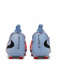 Baskets de soccer bleu clair avec des accents rouges, logo swoosh noir et design texturé. Présente une languette au talon pour un enfilage facile.