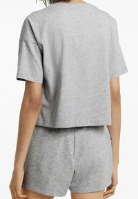 Harmaa lyhythihainen t-paita, joka on valmistettu pehmeästä puuvillasekoitekankaasta. T-paidassa on rento malli ja se on yhdistetty matching harmaisiin shortsit.