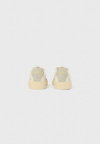 Beežid ja hallid vabaajajalatsid, mille pealiskihiks on seemisnahk ja nahk, ümar varvas, tasased beežid tallad ning kannal tagaosas "DEAN" ja "DAN" kirjaga detailid.