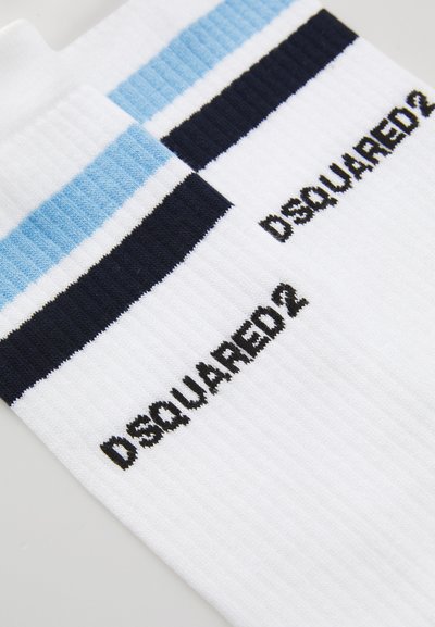 White ribbed socks with black "DSQUARED2" text and blue and black striped cuffs laid flat on a white surface.