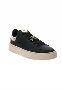 Sneaker di pelle blu navy con suola beige, lacci neri e dettagli metallici dorati sul tallone, con un gioiello decorativo sulla punta.