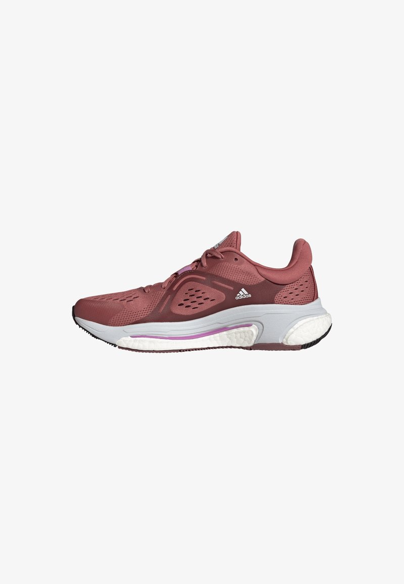Chaussure de course Adidas marron avec semelle blanche et violette amortie, tige en mesh respirant et système de laçage.