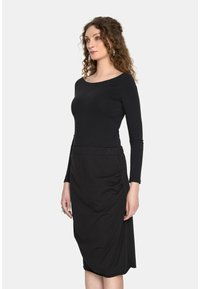 Czarna sukienka z długim rękawem i dekoltem w łódkę; posiada dopasowaną górę i marszczoną spódnicę z bocznymi detalami. Gładka faktura.