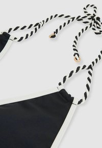 Czarny stanik bikini z białymi wykończeniami, z twistowanymi czarno-białymi ramiączkami oraz złotymi detalami. Gładka tekstura materiału.
