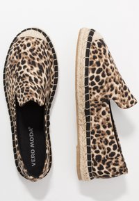 Espadrilles à imprimé léopard avec une bordure noire, une semelle en jute tressé et une tige en tissu doux. Design à enfiler, bout rond, et détails minimalistes.