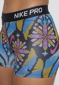 Czarny pas Nike Pro na dopasowanych szortach z kolorowym geometrycznym wzorem kwiatowym w odcieniach niebieskiego, żółtego, różowego i czarnego. Gładki, elastyczny materiał.