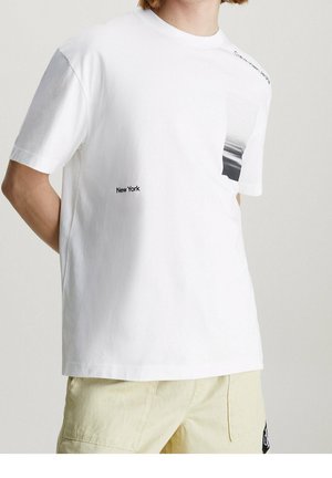 Witte katoenen t-shirt met korte mouwen, featuring een zwart-wit grafisch ontwerp op de borst en "New York" tekst aan de zijkant.