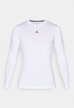 White long-sleeve fitted athletic shirt with a round neckline and a small black Jumpman logo centered on the chest.