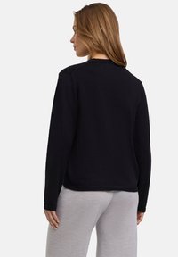 Schwarzes Sweatshirt mit Rundhalsausschnitt, langen Ärmeln und lockerer Passform. Hergestellt aus weichem Stoff mit glatter Textur.