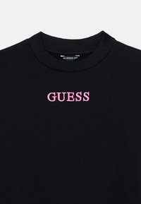 Μαύρο φούτερ με ριμπ λαιμόκοψη και ροζ κεντημένο λογότυπο "GUESS" στο στήθος. Μαλακό ύφασμα με απαλή υφή.