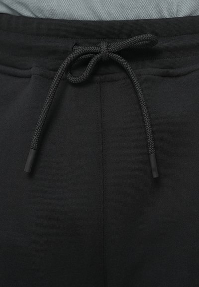 Μαύρο παντελόνι φόρμας με κορδόνι στη μέση, που διαθέτει λεία υφή και κλειστή ραφή κατά μήκος των πλευρών.