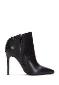 Botín negro de cuero hasta el tobillo con puntera afilada, tacón alto tipo stiletto y detalle de cremallera en el costado. Textura suave y dise�ño minimalista.