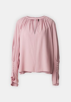 Rosa bluse med nøkkelhulls hals, lange ermer og samlet detalj. Mykt stoff med knappdetaljer på ermekantene.