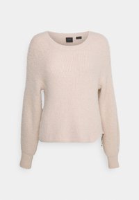 Miękki różowy sweter z prążkowanej dzianiny, z długimi rękawami, okrągłym dekoltem i drobnym zdobieniem w postaci łańcuszka u dołu.