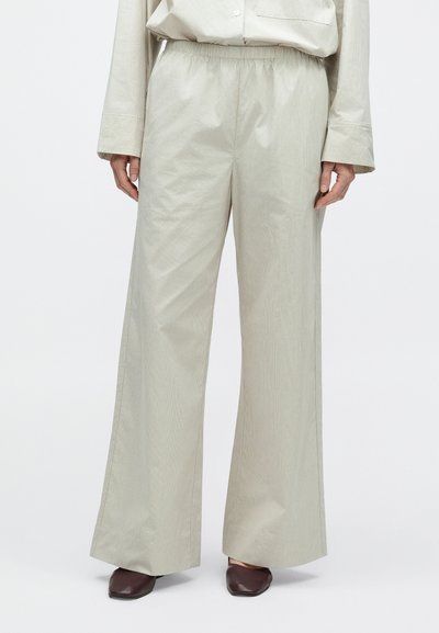 Világosszürke, bő szárú nadrág rugalmas derékpánttal, finom csíkos textúrával és sima, enyhén fényes felülettel.