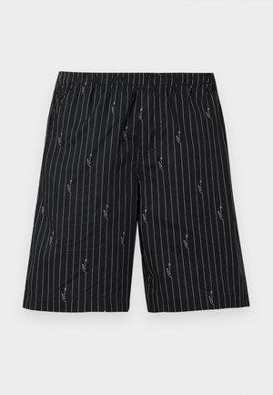 Bermudas negras con rayas verticales blancas y patrones abstractos. Cintura elástica, tejido transpirable, diseño hasta la rodilla.