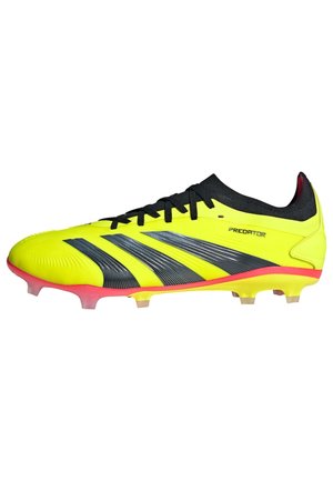 Crampons de soccer jaunes vifs avec des rayures noires, une surface texturée et des accents roses. Présente un design élégant et des crampons pour sol ferme.