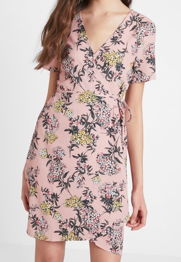 Robe à fleurs rose en wrap avec des manches courtes ; présente des fleurs multicolores en noir, jaune et rose ; comprend un lien à la taille et un ourlet asymétrique.
