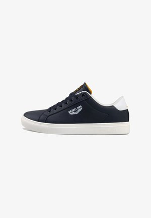 Marineblauwe leren sneaker met een witte rubberen zool, contrasterende gele accenten en logo-detail aan de zijkant. Beschikt over een ronde neus en vetersluiting.