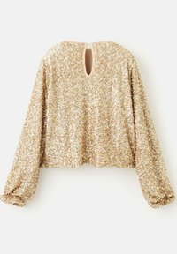 Top in paillettes dorate con maniche lunghe a sbuffo, scollo rotondo e dettaglio con inserto a goccia sulla schiena. Fodera interna morbida per un comfort sulla pelle.