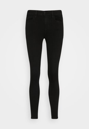 Jeans skinny noirs avec une texture en denim lisse, cinq poches, une fermeture à bouton à l'avant et des passants de ceinture. Design ajusté tout au long.