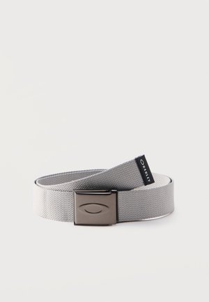 Lysegråt vævet stofbælte med mat metalspænde med indgraveret ovalt logo og et sort Oakley-mærkat.