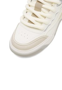 Białe sneakersy z beżowymi akcentami, z grubymi, fakturowanymi sznurowadłami, perforowanym noskiem i warstwową konstrukcją z gumową podeszwą.