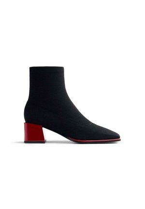 Stivale alla caviglia nero realizzato in tessuto a coste, con punta affusolata e un tacco quadrato rosso lucido con un accento rosso lungo la suola.