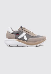 Zapatilla en color beige y gris, hecha de malla y ante, con acentos en blanco, suela redondeada y diseño de cordones. Superficie texturizada para mayor agarre.