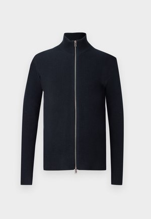 Pull à zip noir côtelé avec col haut et manches longues, présentant une fermeture éclair argentée et une silhouette ajustée.