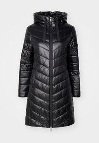 Svart lang polstret frakk med chevron-sømmer, front glidelås, festet hette og svarte snorer.