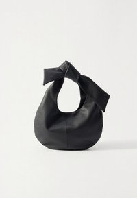 Svart läderväska med rundad form och handtag i form av en knut. Texturerad yta och synliga sömmar längs sidorna.