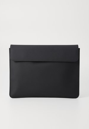 Sac en cuir noir au style enveloppe, avec une texture lisse, fermeture à rabat et un design minimaliste, sans aucune quincaillerie ni accents visibles.