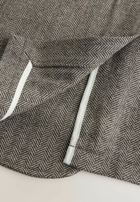 Gray herringbone fabric with a textured pattern; features white piping along the edges and a smooth finish on the surface.