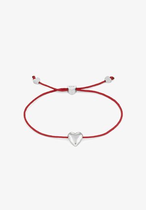 Rød snorarmbånd med en skinnende sølvhjertecharms, der har tre små sølvhjerteaccents. Justerbart design med knyttede ender.