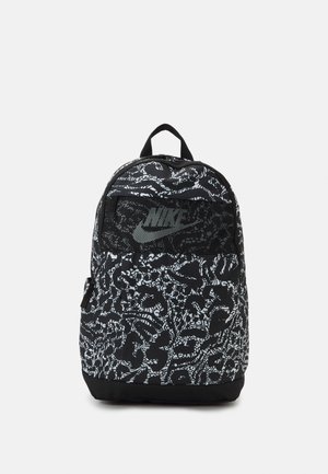 Mochila Nike en blanco y negro con estampado, bolsillo frontal de malla, asa superior y logo visible de Nike sobre un fondo liso.