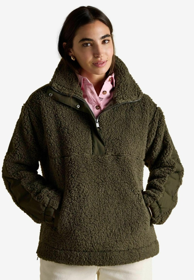 Zielony oliwkowy pulower z polaru z wysokim kołnierzem, półzamkiem z przodu i teksturowaną tkaniną; posiada boczne kieszenie i kontrastujący materiał na rękawach.
