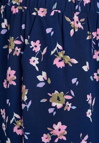 Morska cvetlična tkanina z majhnimi rožnatimi in zelenimi cvetovi, z teksturirano površino in gubanjem v predelu pasu.