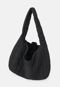 Sac à main noir matelassé avec une forme hobo, doté d'une seule bandoulière allongée et d'une fermeture éclair. Texture douce avec un motif en forme de losange.