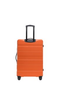 Oranžový kufr s tvrdým skořepinovým povrchem a vodorovnými žebrováními, vysouvací černá rukojeť a čtyři černá kolečka. Vhodný pro cestování.