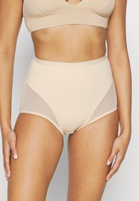 Mutande a vita alta senza cuciture in beige chiaro con pannelli trasparenti sui lati, realizzate in tessuto liscio e elastico.